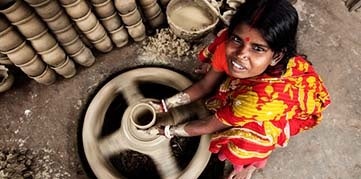 Woman throws clay pot on a pottery wheel in Bangladesh. Photo by Mohammad Reaz Uddin, CGAP Photo Contest