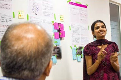 Woman discusses topics such as voice of the customer at Janalakshmi customer experience workshop, India