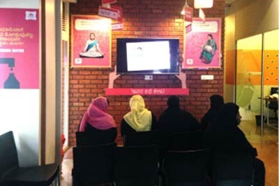 Low-income women customers at a bank branch in Pakistan look at a prototype created through customer experience insights work