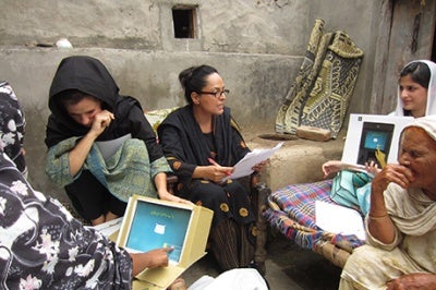 Low-income women customers in Pakistan look at prototype computer screens designed for better, more intuitive, and value-oriented customer experience.