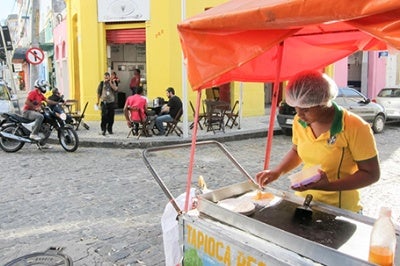 Woman at her street cart. Low-income entrepreneurs like this woman benefit from financial services that offer improved customer experience.