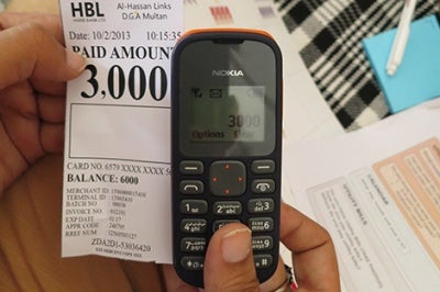 Woman's mobile phone and receipt provide insights into creating customer-centric products and services for low-income customers