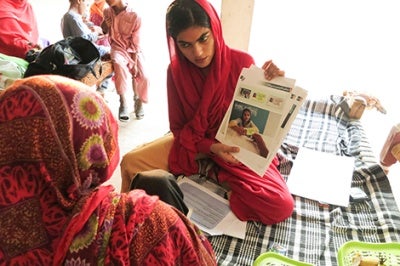 Woman in Pakistan holds a paper as she tests a financial services prototype designed to bring more user-friendly products and services to low-income customers.