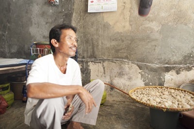 Indonesian man with big pot is interviewed to identify business opportunities to serve low-income customers with customer-centric products and services.
