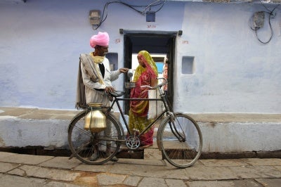 Customer-centricity in action: a customer purchases milk delivered right to her door by a small business entrepreneur in India.