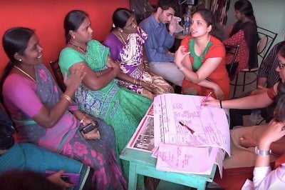 Janalakshmi customers interact with staff at a Janalakshmi branch of the small bank, India.